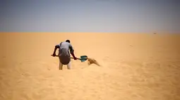 Pekerja menggali lubang untuk terapi menguburkan diri dengan pasir gurun di Siwa, Mesir, 12 Agustus 2015. Terapi mengubur diri di dalam pasir gurun diyakini dapat menyembuhkan rematik, sakit sendi, dan impotensi seksual. (REUTERS/Asmaa Waguih)
