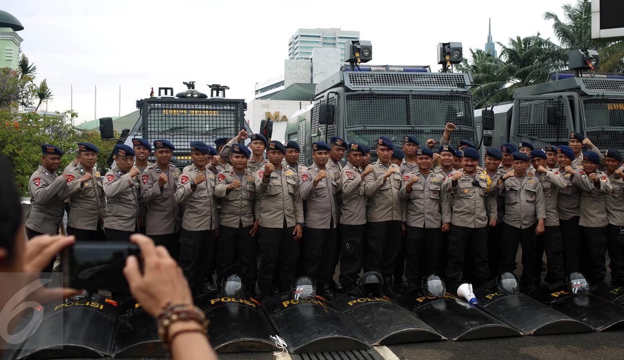 Petugas kepolisian berpose saat berjaga pada Aksi 212 - Jilid 2 di Kompleks Parlemen, Senayan, Jakarta, Senin (20/2). Kurang lebih 10 ribu Pasukan Prajurit Gabungan TNI-Polri di terjunkan saat Aksi tersebut. (Liputan6.com/Johan Tallo)