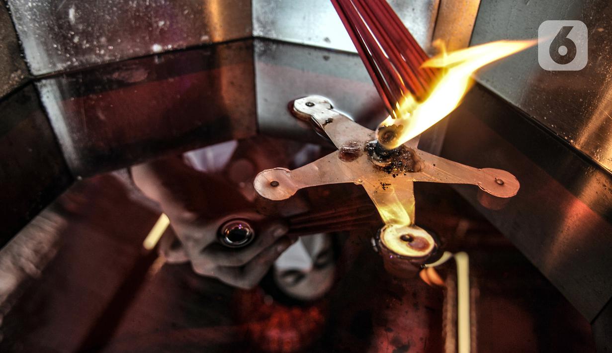 Warga keturunan Tionghoa menyalakan hio saat sembahyang malam Tahun Baru Imlek 2572 di klenteng kawasan Petak Sembilan, Glodok, Jakarta, Kamis (11/2/2021). Berbeda pada tahun sebelumnya, sembahyang malam Imlek kali ini dibatasi hingga pukul 18.00 WIB. (merdeka.com/Iqbal S. Nugroho)