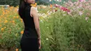 Berpose dengan latar bunga yang indah, seperti inilah penampilan Zize dengan sleeveless dress hitam.   [@azizahsalsha_]