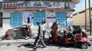 Sejumlah warga mengecek bajaj yang rusak parah usai terkena ledakan bom yang terjadi di Ibu Kota Mogadishu, Somalia (28/3). Hingga kini, belum ada pihak yang bertanggung jawab atas serangan ini. Namun, muncul dugaan kelompok militan berada di balik aksi tersebut. (Reuters/Feisal Omar)