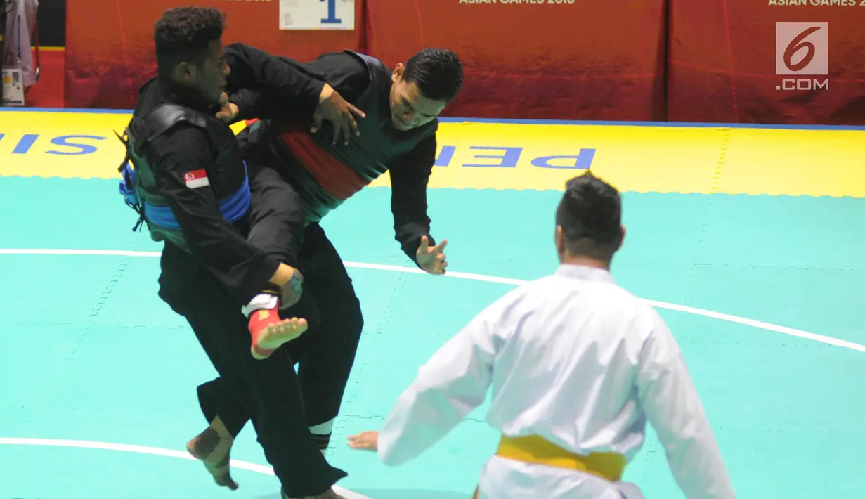 Pesilat Indonesia Aji Bangkit Pamungkas (merah) bertanding melawan pesilat Singapura Sheik Alauddin (biru) dalam babak final Kelas I Putra Asian Games 2018 di TMII, Jakarta, Senin (27/8). Aji berhasil merebut medali emas. (Merdeka.com/Arie Basuki)