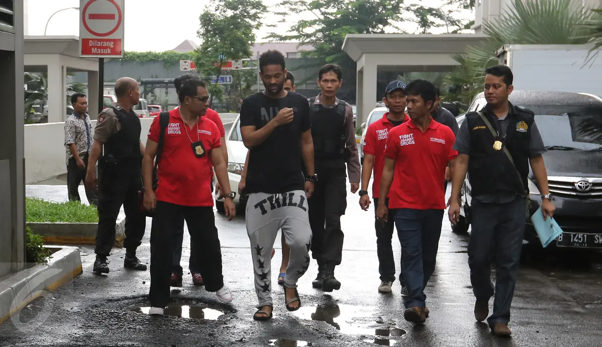 Seorang WNA dibawa petugas untuk menjalani tes urine ketika razia di Apartemen Kalibata City, Jakarta, Kamis (25/2). Ratusan petugas gabungan melakukan razia dalam rangka mengantisipasi peredaran dan penyalahgunaan narkoba. (Liputan6.com/Herman Zakharia)