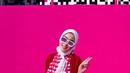 7. Perempuan 40 tahun ini tampak memadukan plaid blouse warna pink dengan cardigan warna merah, serta rok dan hijab warna putih. (Instagram/princessyahrini).