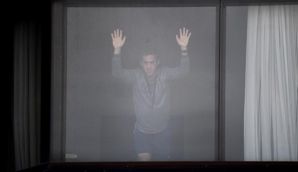 Petenis menunggu dikamar hotel untuk menjalani sesi latihan saat menjalani karantina selama dua minggu setelah kedatangannya di Melbourne, Selasa (19/1/2021). (Foto: AFP/William West)