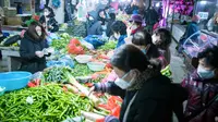 Orang-orang berbelanja sayuran di sebuah pasar di Wuhan, Provinsi Hubei, China, Kamis (23/1/2020). Pemerintah China mengisolasi Kota Wuhan yang berpenduduk sekitar 11 juta jiwa untuk menahan penyebaran virus corona. (Xiao Yijiu/Xinhua via AP)