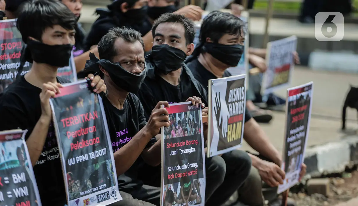 Pengunjukrasa dari Serikat Buruh Migran Indonesia membawa poster dalam aksi di depan Kementerian Ketenagakerjaan, Jakarta, Rabu (18/12/2019). Aksi  memperingati Hari Buruh Migran Internasional itu mendesak Negara bertanggung jawab atas perlindungan hak buruh migran. (Liputan6.com/Faizal Fanani)