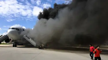 Penumpang dievakuasi dari pesawat Boeing 767-200ER milik maskapai Dynamic International Airways yang terbakar saat akan lepas landas di Bandara Fort Lauderdale, Florida, Kamis (29/10). 15 orang terluka akibat kejadian tersebut. (AFP PHOTO/Andres Gallego)