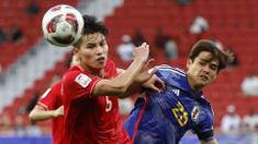 Pemain Vietnam, Nguyen Thanh Binh (kiri) berebut bola dengan pemain Jepang, Kaishu Sano pada laga Grup D Piala Asia 2023 di Al Thumama Stadium, Qatar, Minggu (14/01/2024). (AFP/Karim Jaafar)