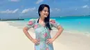 <p>Titi Kamal mengenakan mini dress motif floral berposi di pinggir pantai. (Foto: Instagram titi_kamall)</p>