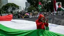 Pengunjuk rasa membentangkan bendera Palestina di depan Kedubes Amerika Serikat, Jumat (21/5/2021). Aksi yang diikuti berbagai elemen masyarakat dan ormas itu mengutuk serangan Israel dan mengajak masyarakat Indonesia untuk mendukung dan membantu Palestina. (Liputan6.com/Faizal Fanani)