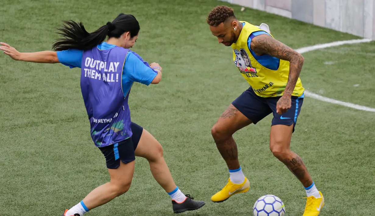 Bintang sepak bola Brasil, Neymar (kanan) mencoba menggocek lawan dalam turnamen untuk badan amal Neymar Junior Project Institute di Praia Grande, Sao Paulo, Brasil, Sabtu (21/7). (AP Photo / Nelson Antoine)