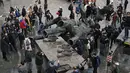 <p>Wartawan dan penduduk setempat melihat monumen era Soviet untuk persahabatan antara Rusia dan Ukraina yang dibongkar oleh pekerja, di tengah invasi Moskow di Kiev, Ukraina, Selasa (26/4/2022). Patung itu terletak di bawah 'Lengkungan Persahabatan Rakyat' titanium raksasa, yang didirikan pada 1982 untuk memperingati ulang tahun ke-60 Uni Soviet. (Genya SAVILOV / AFP)</p>
