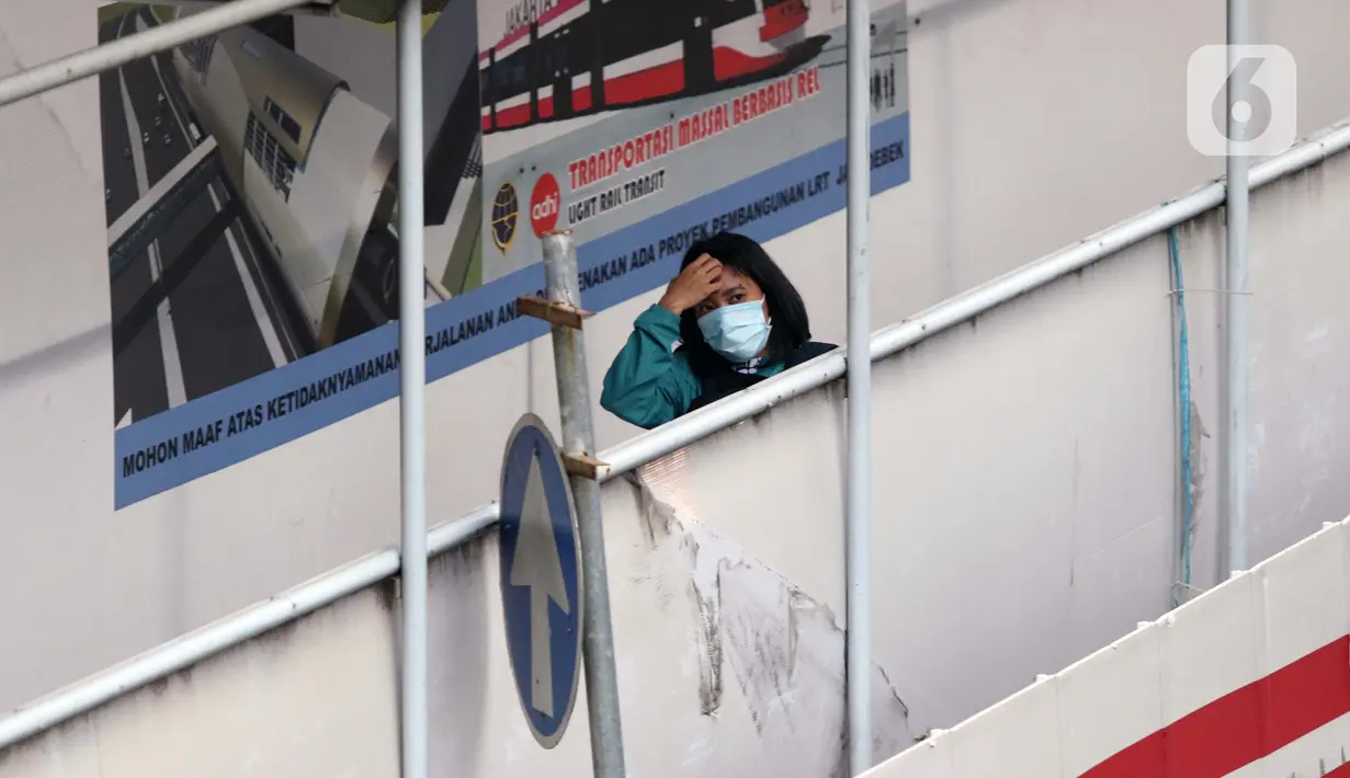 Warga menuju tangga JPO di Jalan HR Rasuna Said, Jakarta, Kamis (7/1/2021). Untuk menyeragamkan kebijakan pengendalian COVID-19, Gubernur DKI Jakarta akan segera menerbitkan Pergub untuk Pemberlakuan Pembatasan Kegiatan Masyarakat (PPKM) pada 11-25 Januari 2021. (Liputan6.com/Helmi Fithriansyah)