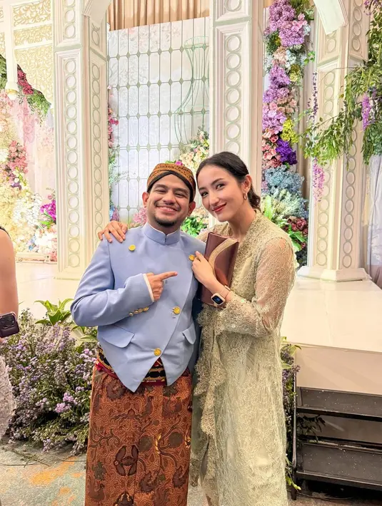 Di momen resepsi, Fadil Jaidi berganti mengenakan beskap biru, tetap dengan padu padan kain batik sebagai bawahan, juga blangkon dan selopnya. [Foto: Instagram/fadiljaidi]