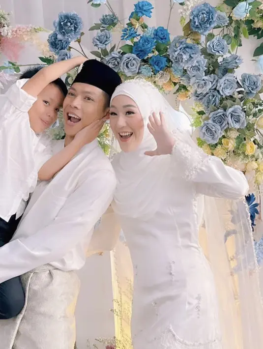 <p>Sedangkan sang suami tampil dengan atasan lengan panjang putih serasi dengan bawahannya. Lengkap dengan sarung yang dilipat. Sang anak pun tampil mengenakan kemeja putih.[@larissachou]</p>