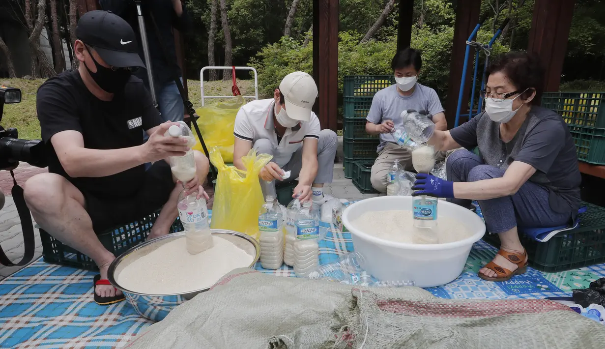 Para pembelot Korea Utara mengisi botol-botol plastik dengan beras dan masker untuk dikirim ke Korea Utara dengan balon, Seoul, Korea Selatan, Kamis (18/6/2020). Pembelot akan tetap mengirimkan propaganda ke Korea Utara di tengah situasi perbatasan yang memanas. (AP Photo/Ahn Young-joon)