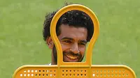 Gelandang Liverpool asal Mesir Mohamed Salah tersenyum saat mengikuti sesi pelatihan di stadion Anfield, Inggris (21/5). Liverpool akan bertanding melawan wakil Spanyol, Real Madrid pada babak Final Liga Champions. (AFP Photo/Paul Ellis)