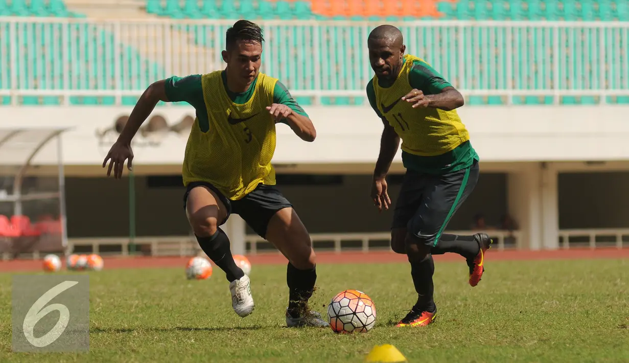 Ryuji Utomo (kiri) berebut bola dengan Boaz Salossa saat seleksi timnas Indonesia tahap pertama di Stadion Pakansari, Bogor, Selasa (9/8). Sementara, prestasi terbaik Indonesia di AFF hanya Runner Up. (Liputan6.com/Helmi Fithriansyah)