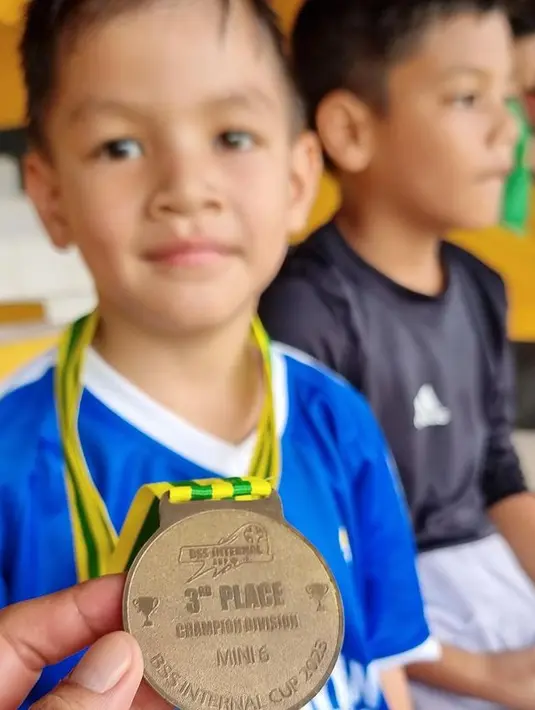 Momen Kai dengan medali yang baru saja didapat. Bahkan, saking senangnya, minta foto diperbesar dan dipajang di kamar. "Minta fotonya digedein dipajang di kamar," lanjut Tikam.  [Instagram/titi_kamall]