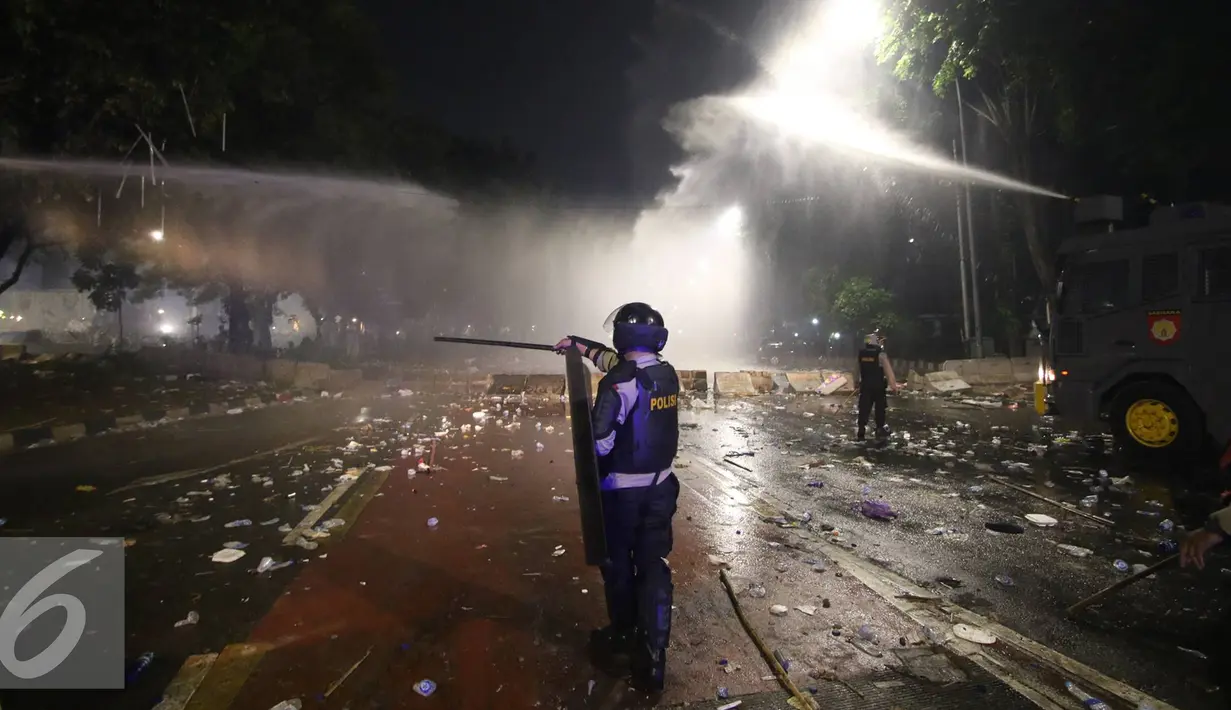 Polisi memukul mundur pendemo dengan tembakan air, Jakarta, Jumat (4/11). Diduga bentrok terjadi saat massa HMI menyerang polisi dan polisi membalasnya dengan melempar gas air mata. (Liputan6.com/Immanuel Antonius)