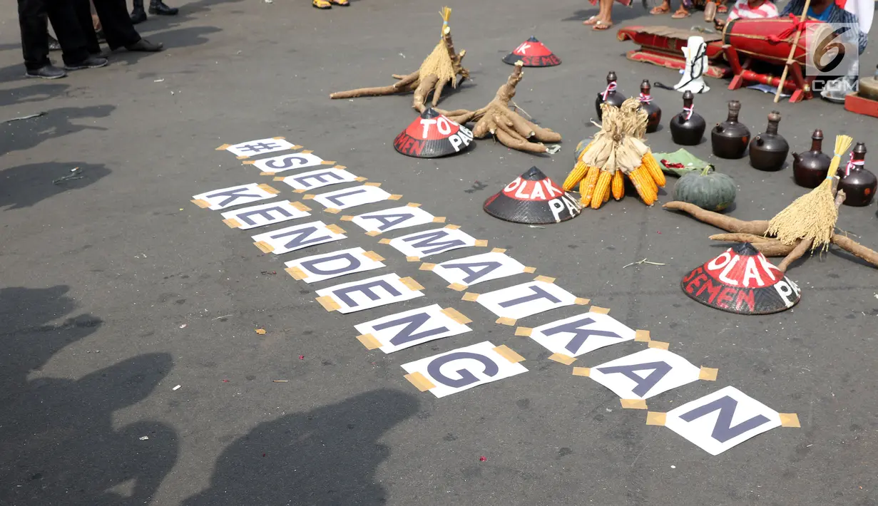 Tulisan #selamatkan kendeng terpampang saat aksi di depan Istana Negara, Jakarta, Kamis (2/8). Dalam aksinya, mereka melakukan tradisi Brokohan memperingati pertemuan mereka dengan Presiden Jokowi. (Liputan6.com/Helmi Fithriansyah)