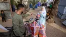 Fanous menjadi simbol suka cita, harapan, dan tradisi yang tetap bertahan di tengah situasi konflik berkepanjangan antara Israel dan Hamas. Tampak dalam foto, Rehan Hazem Sharab, seorang pengungsi Palestina berusia 32 tahun, mengantarkan lampion buatan tangannya, yang dibuat dari kotak-kotak bantuan bekas, sebagai persiapan menyambut bulan suci Ramadan yang dimulai pada 17 Februari, di luar tendanya di lingkungan Al-Mawasi, Khan Younis, di Jalur Gaza selatan pada Sabtu 7 Februari 2026. (Bashar Taleb/AFP)