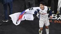 Pemain Tottenham Hotspur, Son Heung-min menangkap bendera Korea Selatan yang dilemparkan oleh penonton setelah laga final Liga Europa 2024/2025 melawan Manchester United di Stadion San Mames, Bilbao, Spanyol, Kamis (22/05/2025) WIB. (AFP/Ander Gillenea)