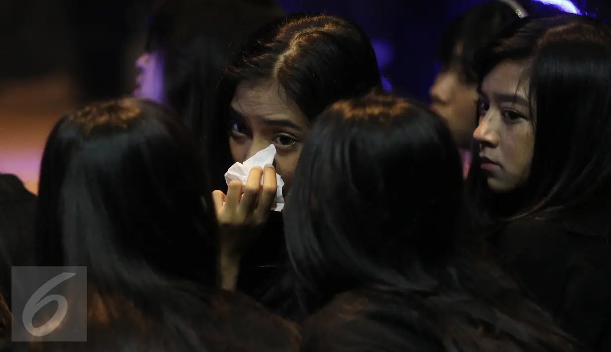 Member grup idol JKT 48 saat mengheningkan cipta dan doa bersama di JKT48 Theater, Jakarta, Senin (27/03). (Liputan6.com/Herman Zakharia)