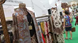 Pengunjung melihat-lihat koleksi batik yang dipamerkan pada Interior and Craft (ICRA) Exhibition 2019 yang dihelat di Hall A Jakarta Convention Center (JCC), Senayan, Jakarta, Minggu (6/10/2019). Ratusan motif batik dari berbagai daerah dipamerkan pada ajang ini. (Liputan6.com/Helmi Fithriansyah)