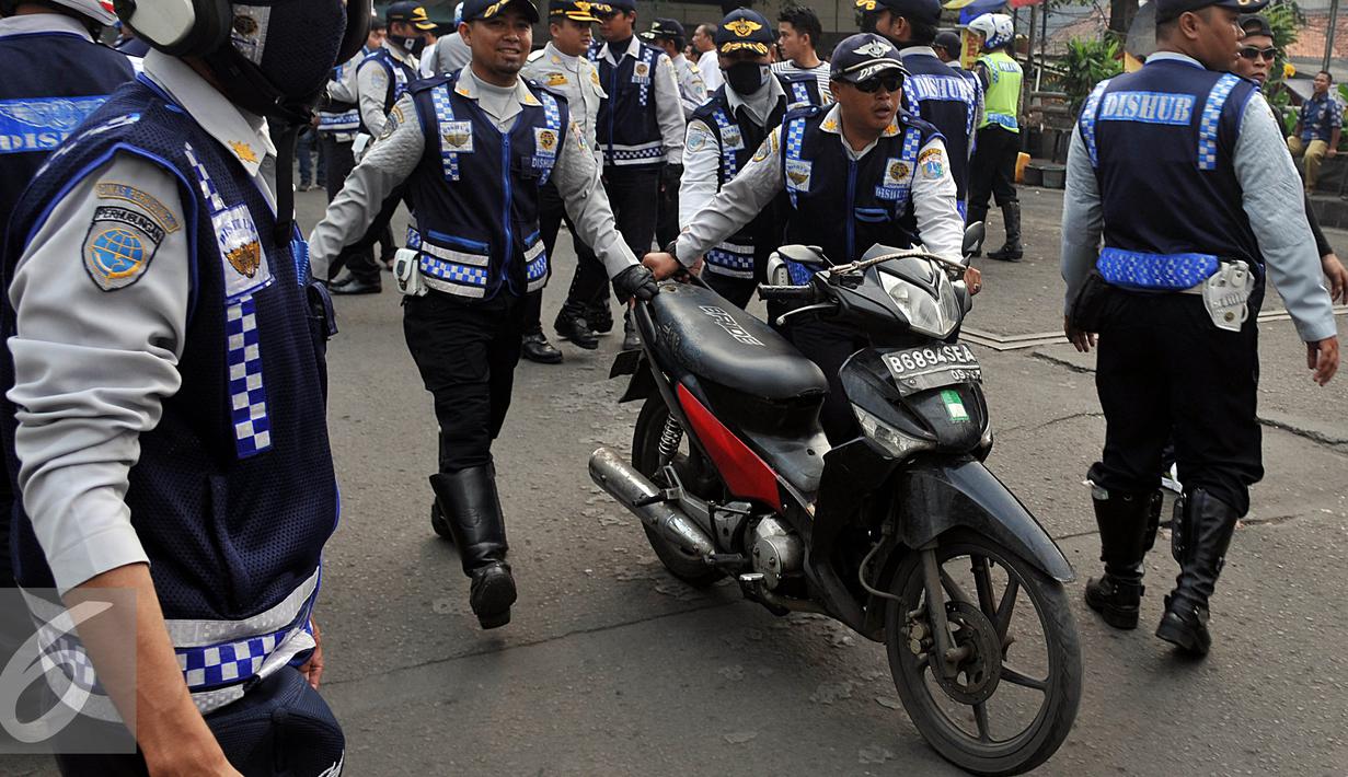 Petugas Dishub, membawa sepeda motor saat razia gabungan di kawasan Tanah Abang, Jakarta, Jumat (12/6/2015). Razia gabungan Dishub, Garnisun dan Satlantas bertujuan untuk mengembalikan fungsi trotoar sebagai jalur pedestrian. (Liputan6.com/Johan Tallo)