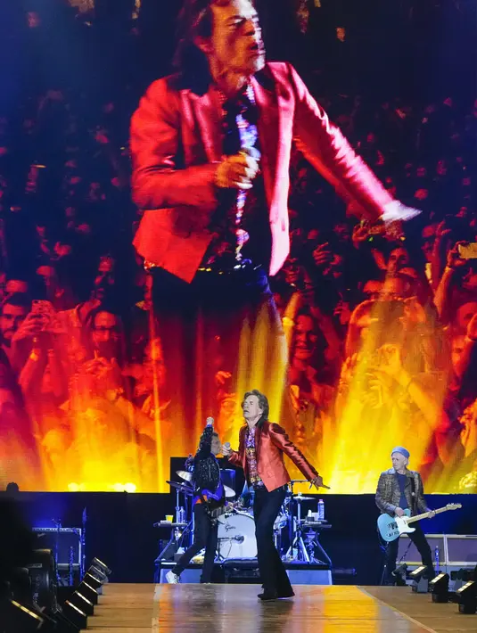 Personel grup band The Rolling Stones Mick Jagger ditampilkan pada layar, Ronnie Wood (kiri), dan Keith Richards (kanan) tampil pada tur Sixty Stones Europe 2022 di Stadion Wanda Metropolitano, Madrid, Spanyol, 1 Juni 2022. (AP Photo/Manu Fernandez)