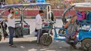 Pengemudi becak listrik minum air pada siang hari yang panas di New Delhi, India, Rabu 20 Mei 2026. (AP Photo/Manish Swarup)