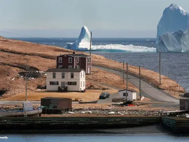 Sebuah bongkahan es raksasa melewati perairan Ferryland Newfoundland, Kanada, (10/4). Perairan yang disebut Iceberg Alley ini menjadi tempat perlintasan pecahan gletser di Greenland pada setiap awal musim panas. (Paul Daly/The Canadian Press via AP)