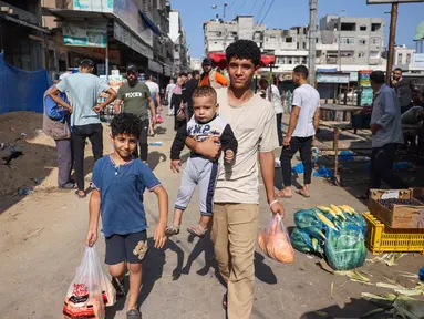 Orang-orang membeli produk segar di sebuah pasar di kota Gaza, pada 10 Oktober 2023. (Mohammed ABED / AFP)