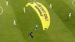 Para pemain melihat paraglider Greenpeace mendarat di stadion sebelum pertandingan Grup F Euro 2020 antara Prancis dan Jerman di Allianz Arena, Munich, Jerman, Selasa (15/6/2021). Pada parasut kuning sang aktivis tertulis "Kick Out Oil! Greenpeace". (AP Photo/ctivist Alexander Hassenstein, Pool)