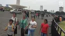 Sejumlah pengunjung menikmati suasana kawasan Silang Monumen Nasional (Monas), Jakarta, Sabtu (30/12). Monumen setinggi 132 meter tersebut tak pernah sepi dari pengunjung, apalagi bila menjelang tahun baru. (Liputan6.com/Immanuel Antonius)