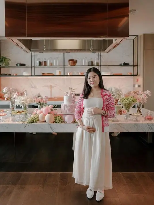 <p>Ia terlihat tampil cantik dengan mengenakan gaun putih yang dipadu outer warna pink. Valencia tampak tak bisa menyebunyikan ekspresi terkejut sekaligus senang. [Foto: instagram.com/valenciatanoe]</p>