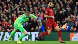 Penyerang Liverpool, Mohamed Salah menggiring bola melewati kiper Everton, Jordan Pickford selama pertandingan Liga Inggris di Anfield Stadium (2/12). Liverpool menang tipis 1-0 atas Everton. (AP Photo / Jon Super)