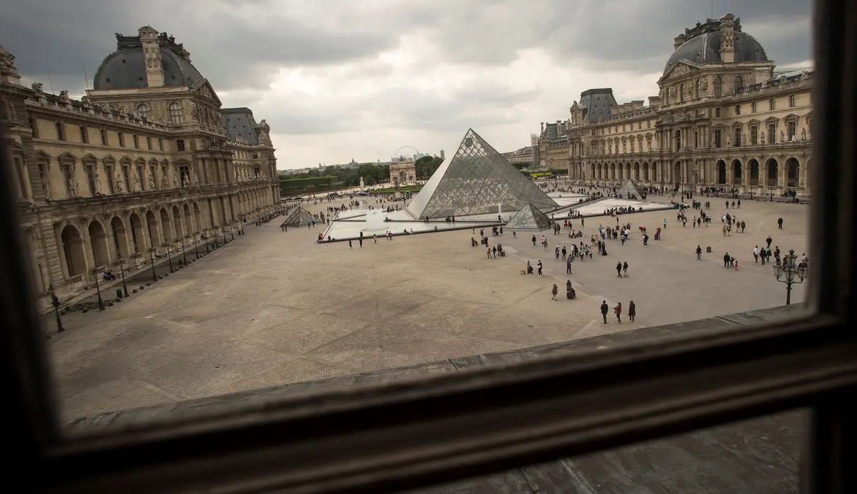 Piramida Louvre yang berada di taman Museum Louvre terlihat dari sebuah kaca jendela di Paris, 16 Mei 2016. (LIONEL Bonaventure/AFP)