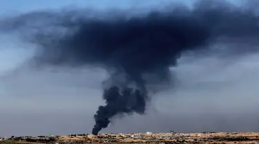 Sebuah foto yang diambil dari Israel selatan menunjukkan asap hitam mengepul di atas Jalur Gaza selama pengeboman Israel pada 18 Januari 2024. (JACK GUEZ/AFP)