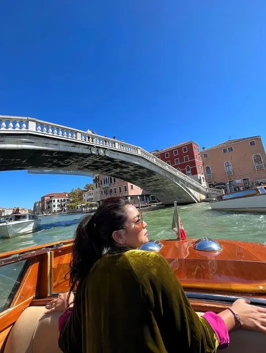 Ia santai memadukan outer velvet hijau lumut dengan kaos putih. celana jeans, dan sepatu putih.