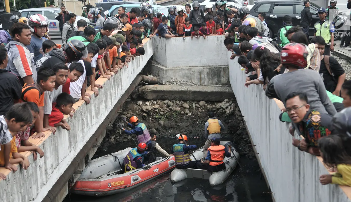 Warga dan pengendara berkerumun melihat upaya tim gabungan melakukan pencarian buaya di Kali Grogol, Jakarta Barat, Kamis (28/6). Pencarian telah dilakukan sejak kemarin siang ketika warga melaporkan penampakan buaya itu. (Merdeka.com/Iqbal S. Nugroho)