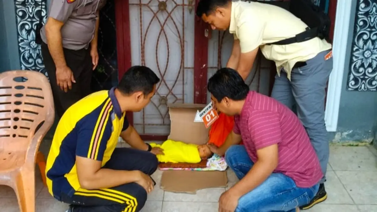 Personel Polresta Pekanbaru melakukan olah tempat kejadian perkara bayi dibuang orang tua dalam kardus.