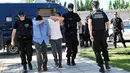 Polisi mengamankan dua dari 8 perwira militer pendukung kudeta Turki, di Alexandroupoli, utara Yunani, Minggu (17/7). 8 pria yang terbang dengan helikopter militer Turki itu ditahan petugas keamanan Yunani karena masuk secara ilegal (Sakis MITROLIDIS/AFP)