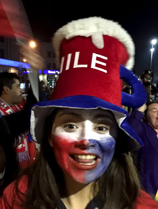 Suporter wanita chili bergembira merayakan kemenangan Chili atas Peru di Copa Amerika 2015 di kota Santiago, (29/6/2015). Chile melaju ke final usai mengalahkan Peru 2-1 berkat dua gol Eduardo Vargas. (REUTERS/Jorge Adorno)