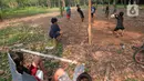 Anak-anak menonton temannya bermain sepak bola di lahan kebun Karet desa Cibodas, Bogor, Jawa Barat Sabtu (4/9/2021). Meskipun lapangan sepak bola seadanya berada di lahan Kebun karet, anak-anak bermain dengan semangat berlatih dan sering ikut turnamen antar kampung. (merdeka.com/Imam Buhori)