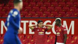 Pemain Manchester United, Edinson Cavani, berbincang dengan Paul Pogba saat pertandingan melawan Chelsea pada laga Liga Inggris di Stadion Old Trafford, Minggu (25/10/2020). Kedua tim bermain imbang 0-0. (Oli Scarff/Pool via AP)