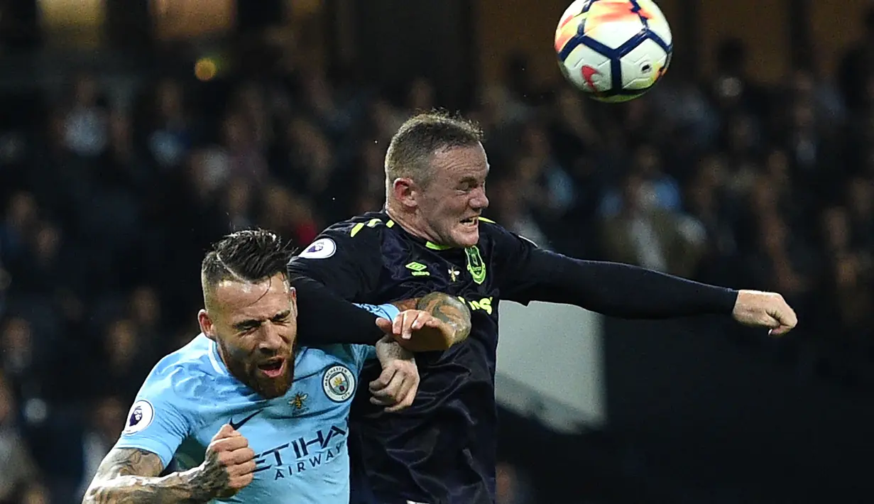 Bek Manchester City Otamendi berebut bola di udara dengan Striker Everton Wayne Rooney saat pertandingan Liga Primer Inggris di Stadion Etihad, Manchester (21/8). (AFP/Oli Scarff)
