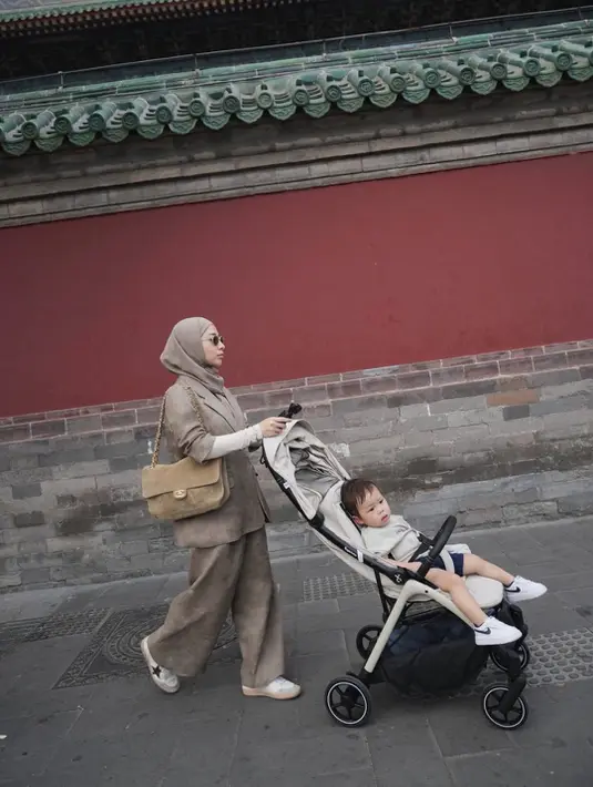 Di salah satu foto, Nikita tampil chic mengenakan setelan bernuansa taupe lengkap dengan blazer loose fit dan wide leg pants. Hijab berwarna senada membuat keseluruhan look tampak harmonis dan mahal secara effortless. Penampilannya semakin elevated lewat sunglasses klasik serta shoulder bag suede bernuansa beige dengan detail gold chain yang memperkuat sentuhan old money aesthetic. [Dok/@nikitawillyofficial94].